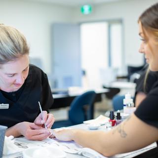 A student practices nail work on another student in the aesthetics and spa therapy classroom at VIU.