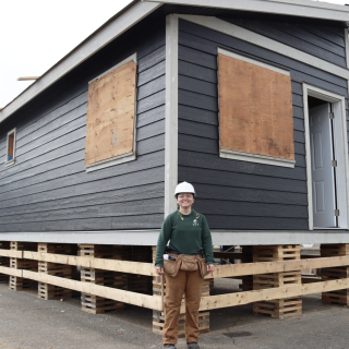 Carpentry student Emily Behm standing in front of the tiny home she and her classmates are building at the Cowichan Trades Centre