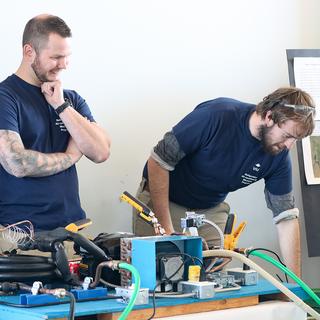 Two students showcase their Refrigeration and Air Conditioning Mechanic work for the food sovereignty project.