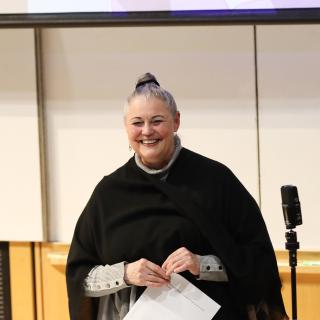 Dr. Vicki Nygaard smiling while standing at the front of a classroom.