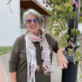 Mary Clare stands next to a lamppost with flowers trailing down it