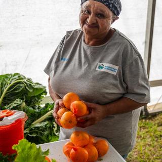 A farmer holding produce in their hands.