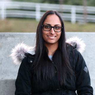 Portrait of Nina Gill sitting and smiling at the camera