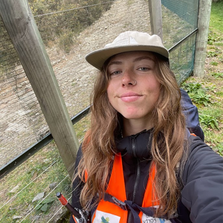 Georgia stands in front of a fence