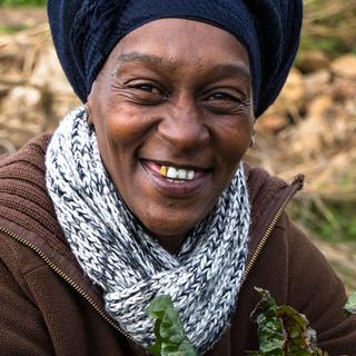 A Rural Women’s Assembly member smiles in a field.