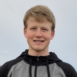 Spencer Antifave wearing a grey hoody outside and smiling at the camera