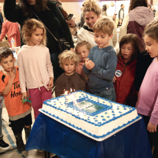 A group of kids admire the birthday cake at VIU tiwšɛmawtxw's  50th birthday celebration