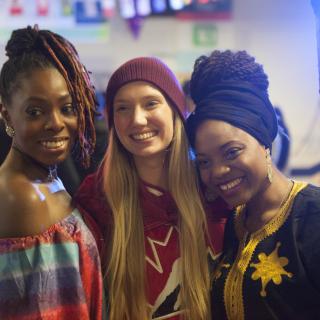 Three women smile at camera