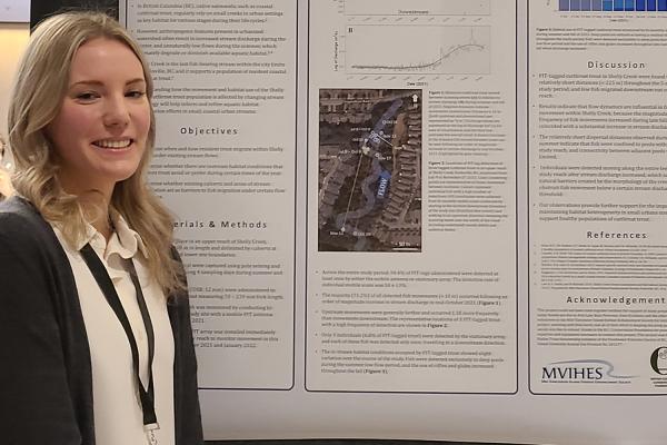 Ally Badger stands in front of a research poster.