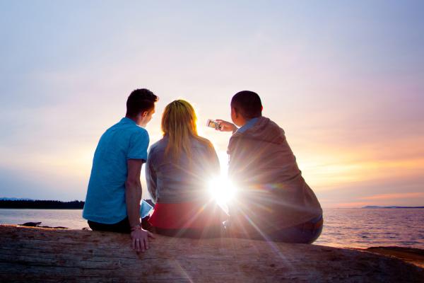 Three students backlit by the sun