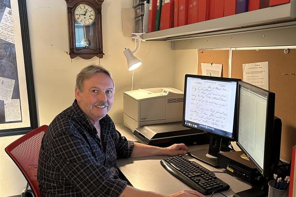 Dr. Stephen Davies sits in front of his computer, which displays a digitized letter