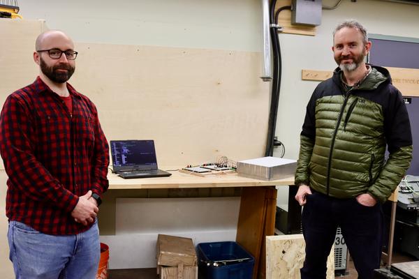 Engineering Technician Devin Ayotte and Resource Management and Protection Technician Michael Lester stand in front of marmot weigh scale