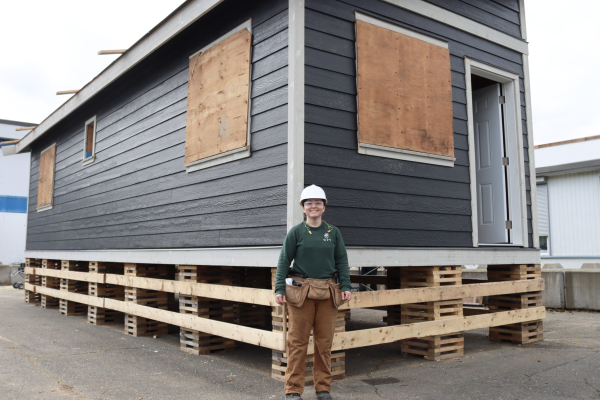 Carpentry student Emily Behm standing in front of the tiny home she and her classmates are building at the Cowichan Trades Centre