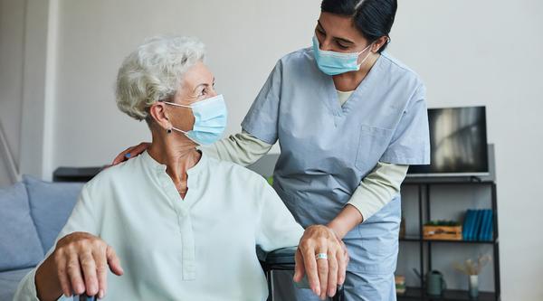 A health-care worker helps a patient