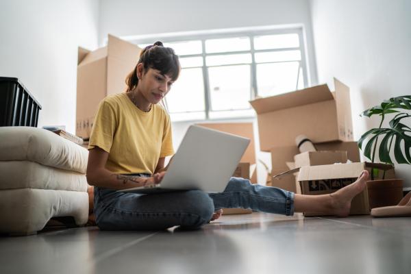 A student looks at a laptop screen surrounded by boxes