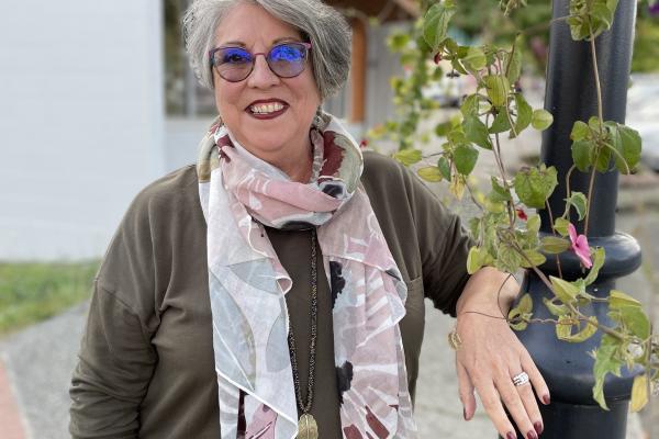 Mary Clare stands next to a lamppost with flowers trailing down it