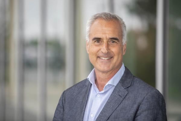 Head shot of Mike Quinn standing in front of the Centre for Health and Science at VIU's Nanaimo campus