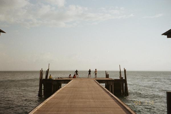 A dock with people on it, ocean behind