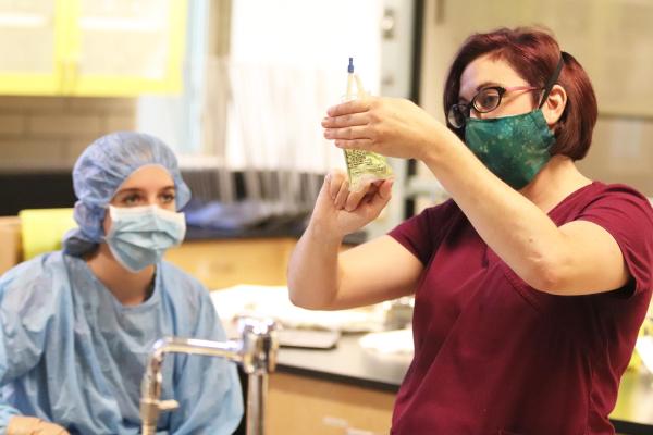 A student in a classroom watching an instructor fill a prescription bottle