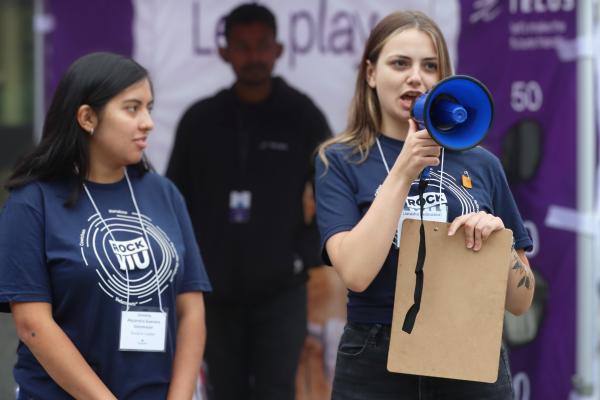 Two students wearing RockVIU shirts, one holding a loudspeaker