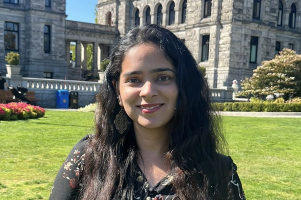 Harleen Kalra standing outside on a sunny day and smiling at the camera.