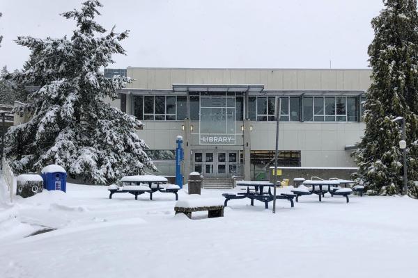 A view of VIU's Nanaimo campus library from the exterior with a snowed-in quad