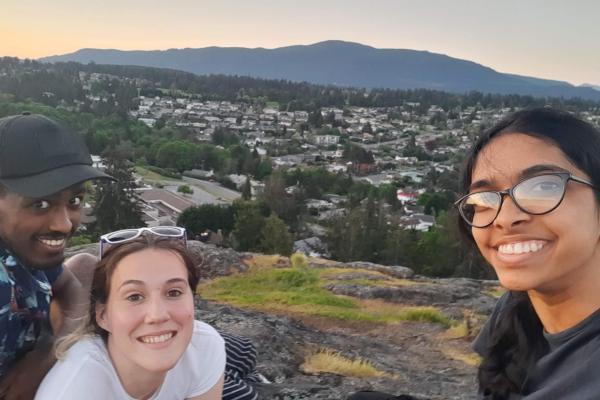 three students pose with the city of Nanaimo in the background