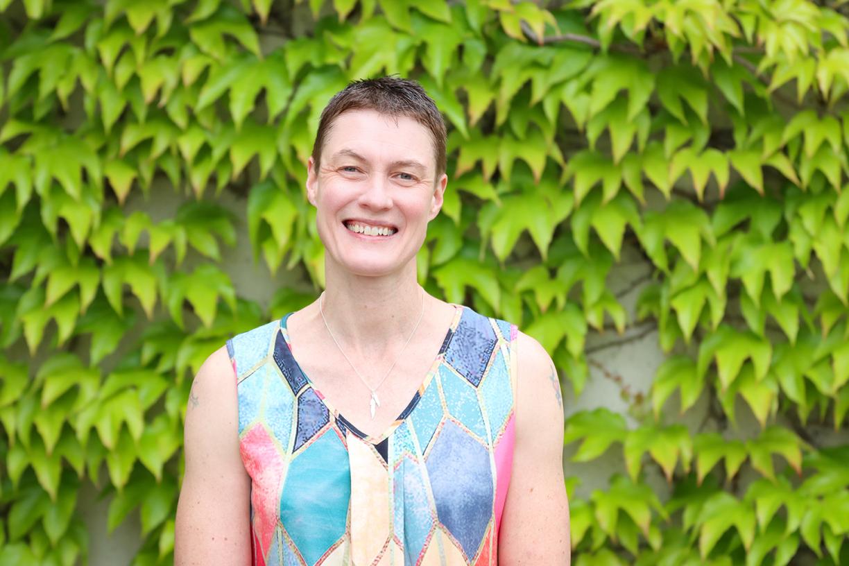 Emily Huner stands in front of foliage at VIU's Nanaimo campus