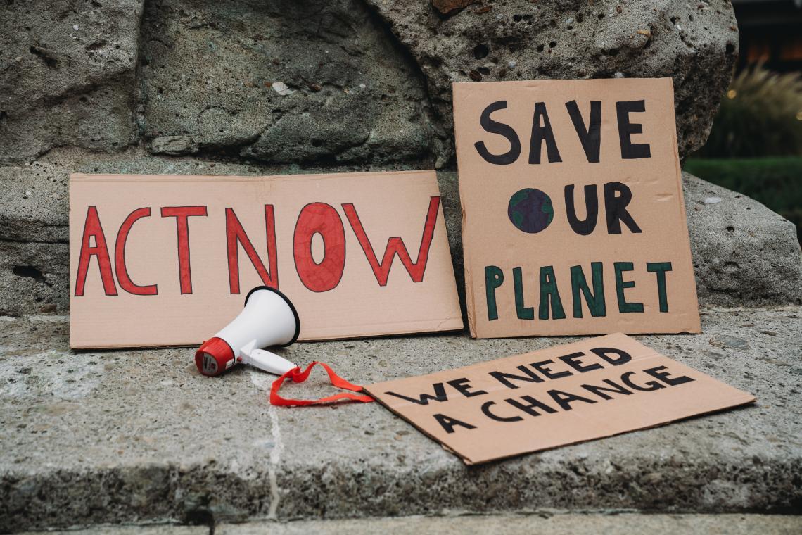 Climate action signs and a loudspeaker on pavement