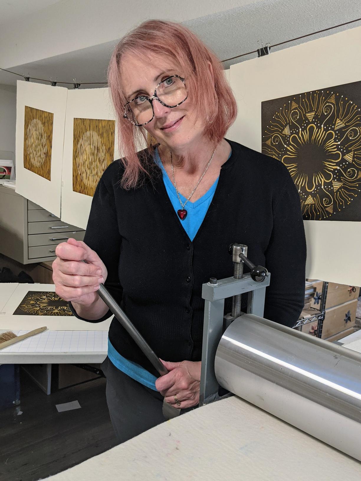 Mary Anne Molcan stands by her print press.