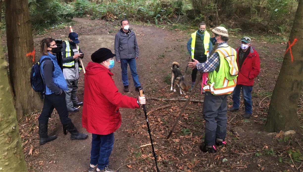 Seven members of the Mid-Island Stewardship Caucus stand in a forest.