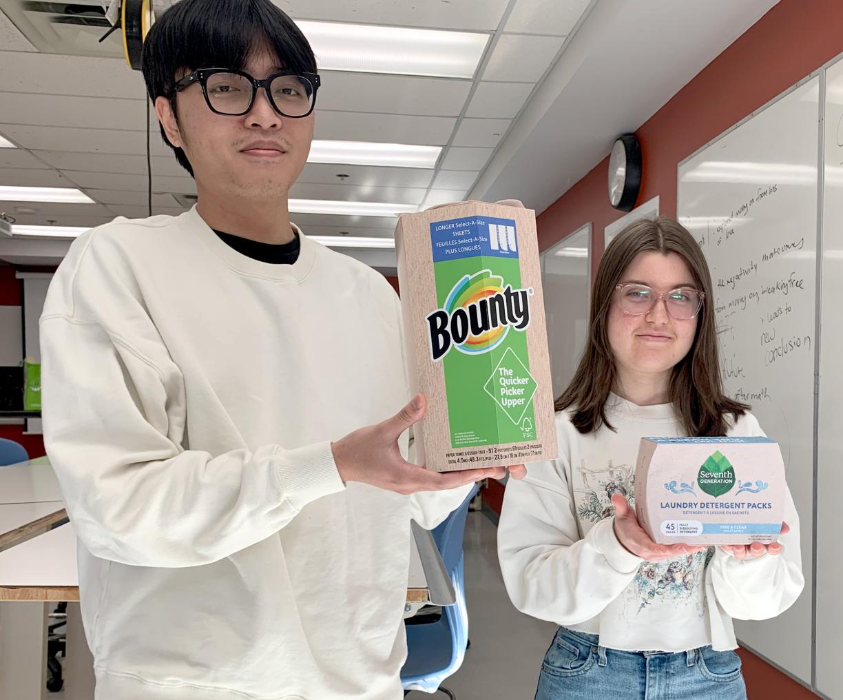 Nathan Pham and Kiara White hold their redesigned product packaging.