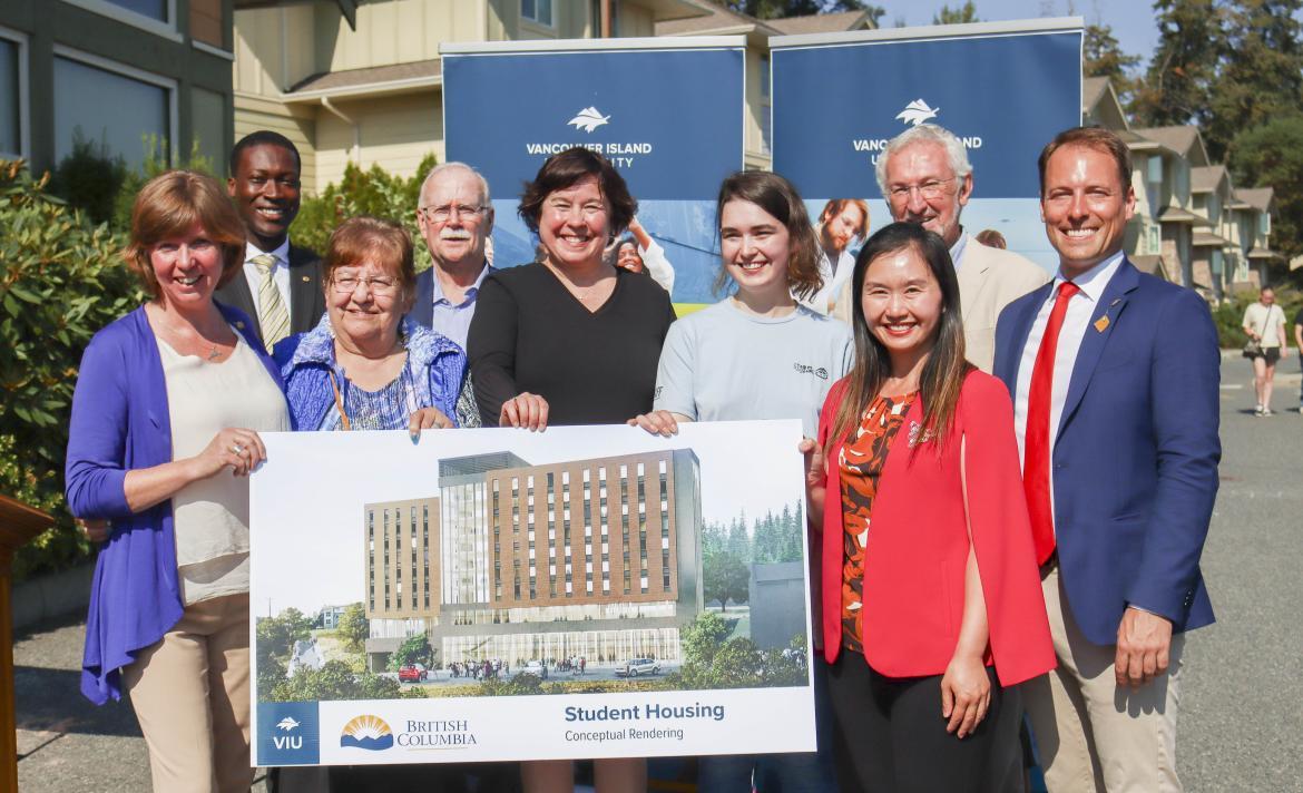 Group holds up a conceptual rendering of the new student housing facility coming to VIU's Nanaimo campus