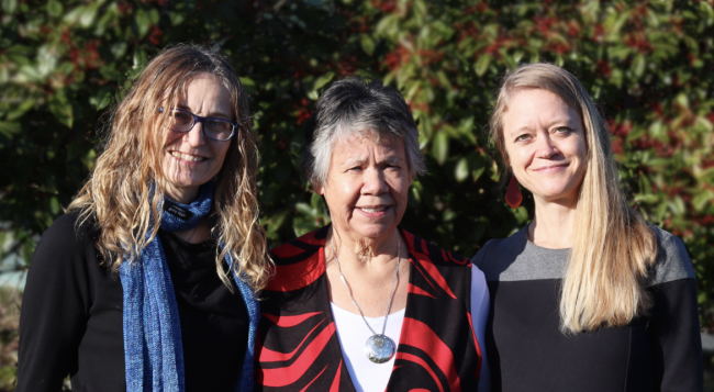 Three women smile at camera