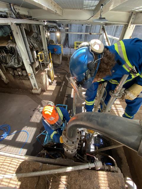 Power engineers work on a pipeline inside a facility