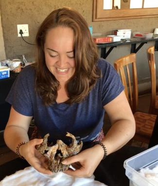 Samantha Good holds the two-million-year-old skull she unearthed.