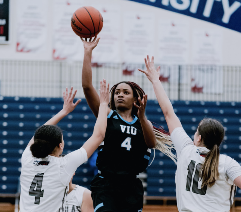 Three basketball players vying for the ball